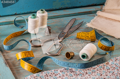 Image of Retro sewing accessories on blue wooden background