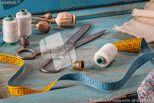 Image of Retro sewing accessories on blue wooden background