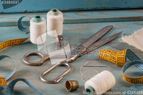 Image of Retro sewing accessories on blue wooden background