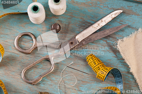 Image of Retro sewing accessories on blue wooden background