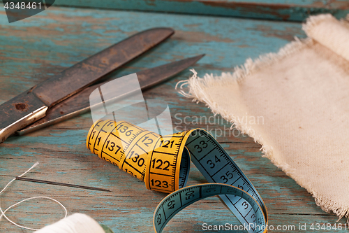 Image of Retro sewing accessories on blue wooden background