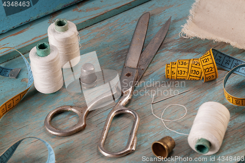 Image of Retro sewing accessories on blue wooden background