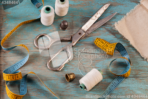 Image of Retro sewing accessories on blue wooden background