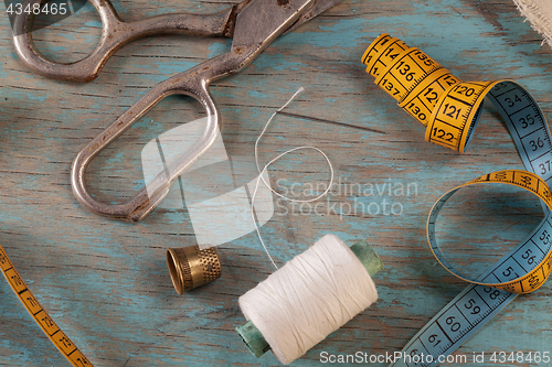 Image of Retro sewing accessories on blue wooden background