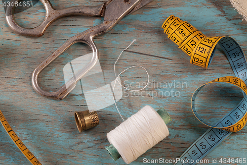 Image of Retro sewing accessories on blue wooden background