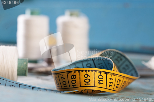 Image of Retro sewing accessories on blue wooden background