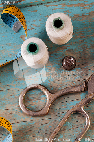 Image of Retro sewing accessories on blue wooden background