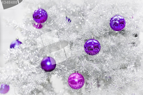 Image of Decoration ultraviolet baubles on silver artificial Christmas tree