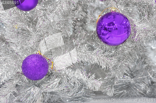 Image of Decoration ultraviolet baubles on silver artificial Christmas tree