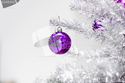 Image of Decoration ultraviolet baubles on silver artificial Christmas tree