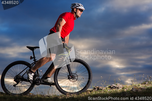 Image of Man in helmet and glasses stay on the bicycle