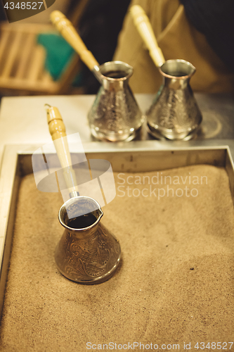 Image of Jezve placed in sand