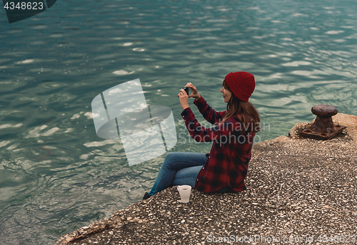 Image of Woman taking pictures with a cellphone