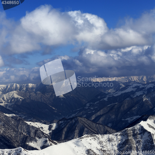 Image of Sunlit winter mountains in clouds, view from off-piste slope