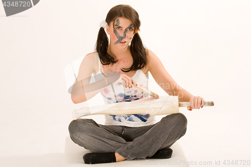 Image of Young woman painting with paint on his face and hands 