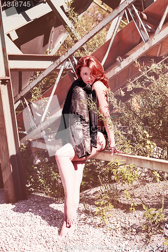 Image of Redhead woman wearing only a leather jacket