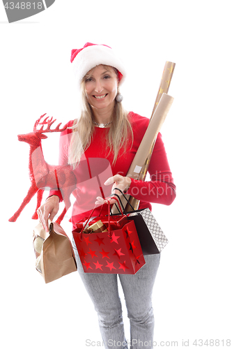 Image of A woman carrying various gifts and decorations for Christmas