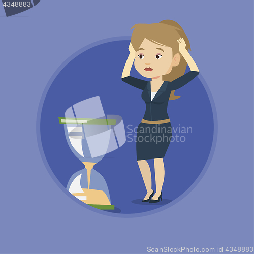 Image of Desperate business woman looking at hourglass.