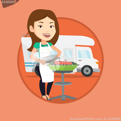 Image of Woman having barbecue in front of camper van.