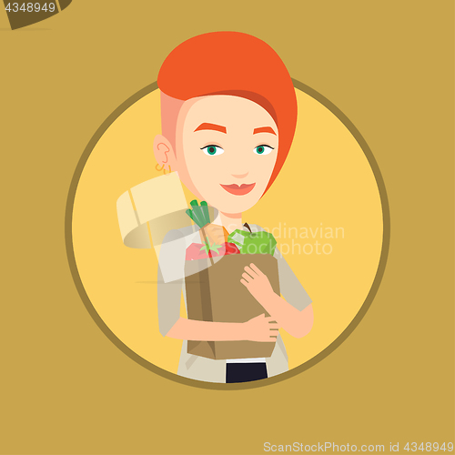 Image of Happy woman holding grocery shopping bag.