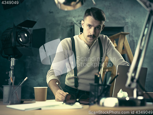 Image of Architect working on drawing table in office