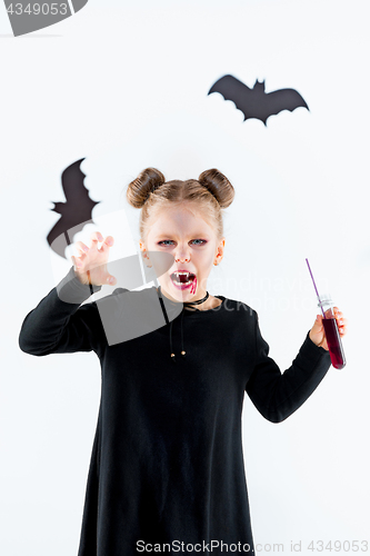 Image of Little girl witch in black dress over magical accessories. Halloween, the studio evening.