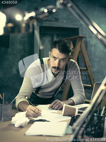 Image of Architect working on drawing table in office