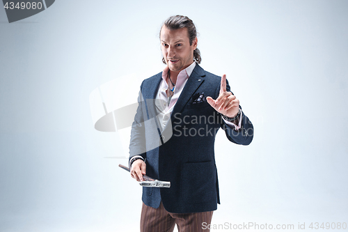 Image of The mature barded man in a suit holding cane.