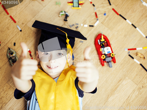 Image of little cute preschooler boy among toys lego at home in graduate 