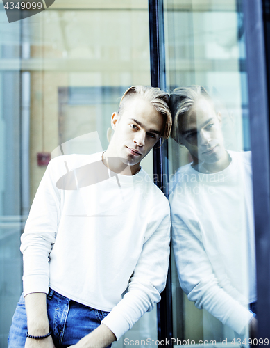 Image of young modern hipster guy at new building university blond fashio