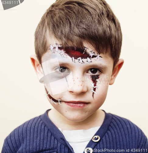 Image of little cute child making facepaint on birthday party, zombie Apo