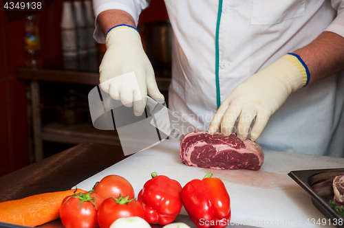 Image of Chef cutting meat