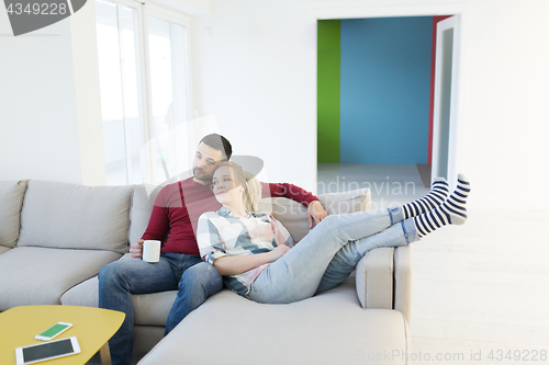 Image of couple hugging and relaxing on sofa