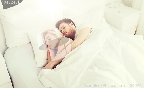 Image of happy couple sleeping in bed at home