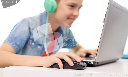 Image of boy in headphones playing video game on laptop