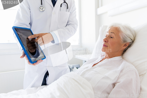 Image of senior woman and doctor with tablet pc at hospital