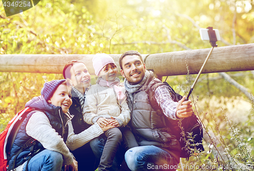 Image of happy family with smartphone selfie stick in woods