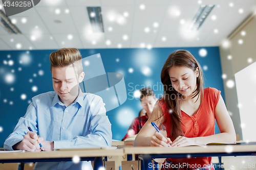 Image of group of students with books writing school test