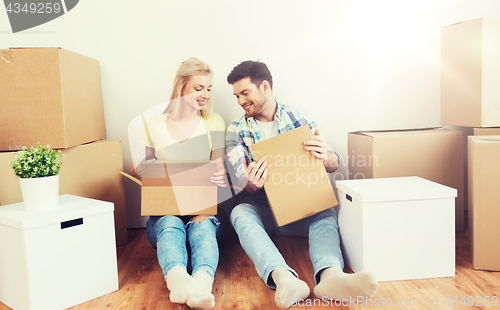 Image of smiling couple with many boxes moving to new home