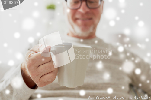 Image of happy senior man with cup of tea or coffee at home