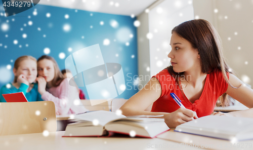 Image of students gossiping behind classmate back at school