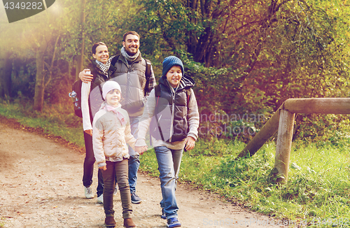 Image of happy family with backpacks hiking in woods