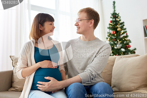 Image of pregnant wife with husband at home at christmas