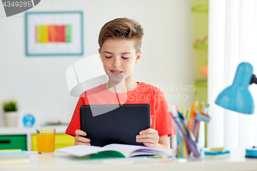 Image of student boy with tablet pc and notebook at home