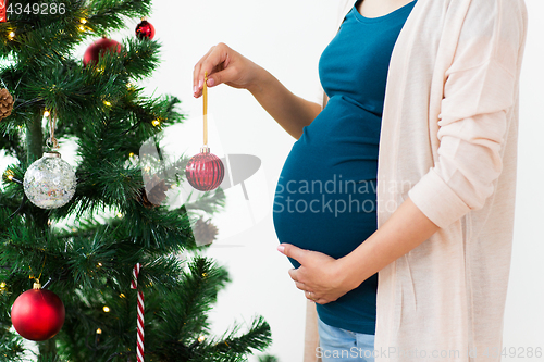 Image of pregnant woman decorating christmas tree