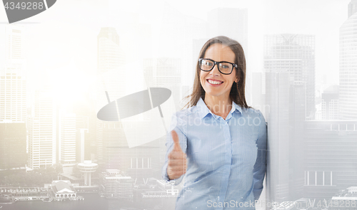 Image of happy smiling woman in glasses showing thumbs up