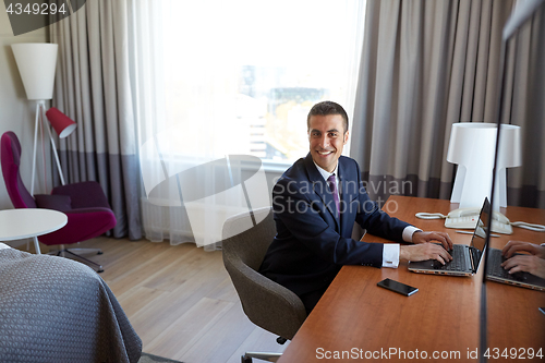 Image of businessman typing on laptop at hotel room