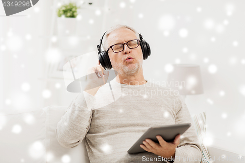 Image of senior man with tablet pc and headphones at home