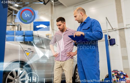 Image of auto mechanic with clipboard and man at car shop