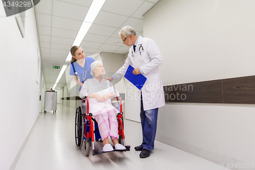 Image of medics and senior patient in wheelchair at clinic